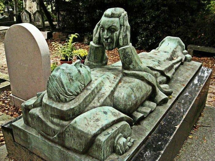 Terrifying grave sculpture of person holding their own head in eerie cemetery scene