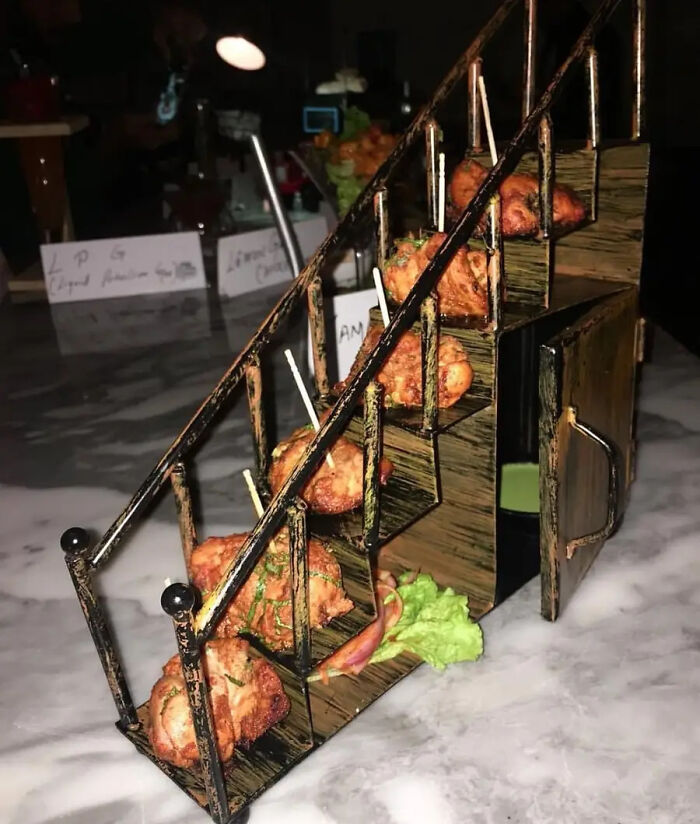 Fried snacks served on a miniature staircase display with lettuce, showcasing ridiculous restaurant food presentation.