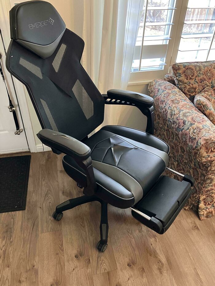 Ergonomic black and gray gaming chair with footrest found as a dumpster diving treasure in a home setting.