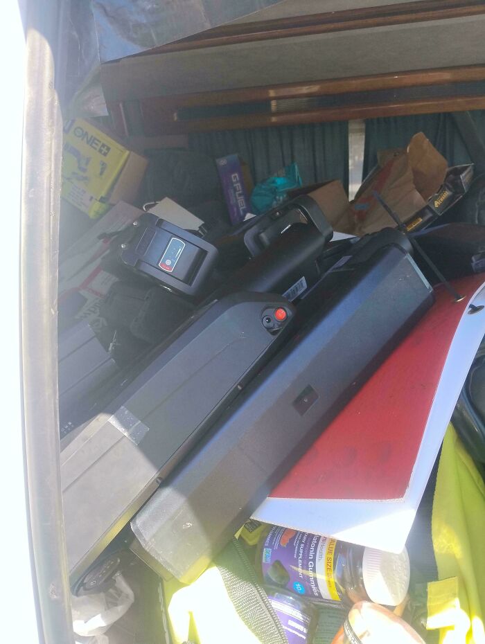 Assorted dumpster diving treasures including electronics, supplements, and gear packed in a vehicle for reuse or resale.