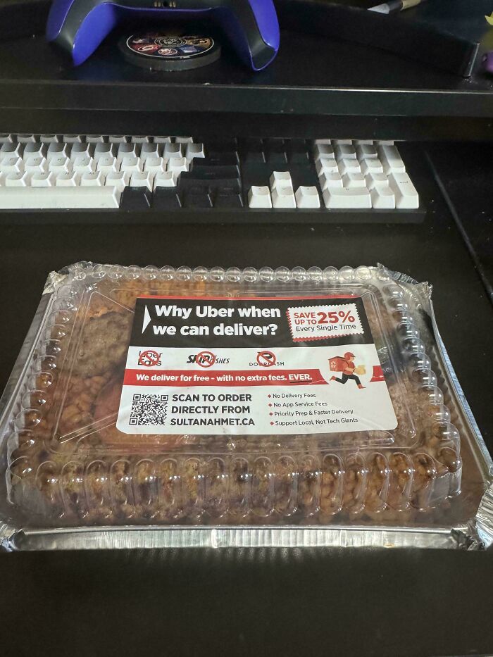 Takeout container with label promoting delivery service as a moderately interesting alternative to Uber Eats on a desk.