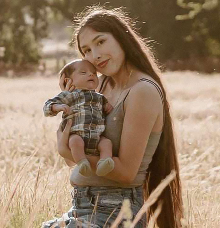 Young mother holding baby in a sunlit field, related to tragic car incident and tougher charges in court case. - 9