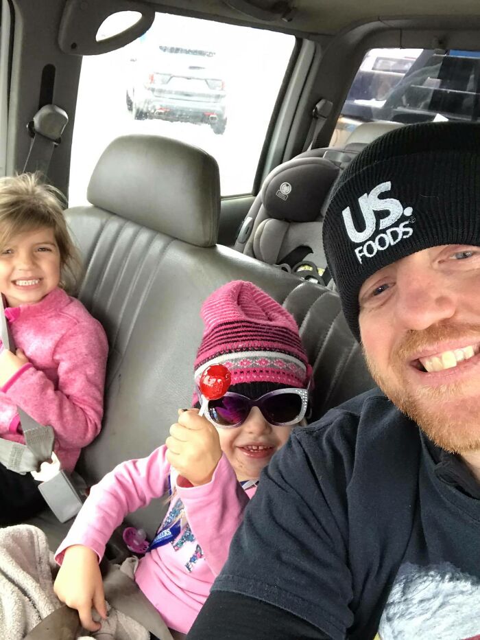 Man wearing US Foods hat smiling with two young girls in a car, related to suspect nabbed in Devil's Den case. - 9