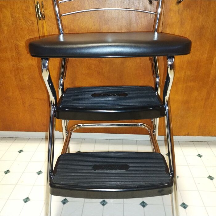 Retro black and chrome step stool chair with ribbed steps on a tiled floor, a classic retro find for old soul enthusiasts