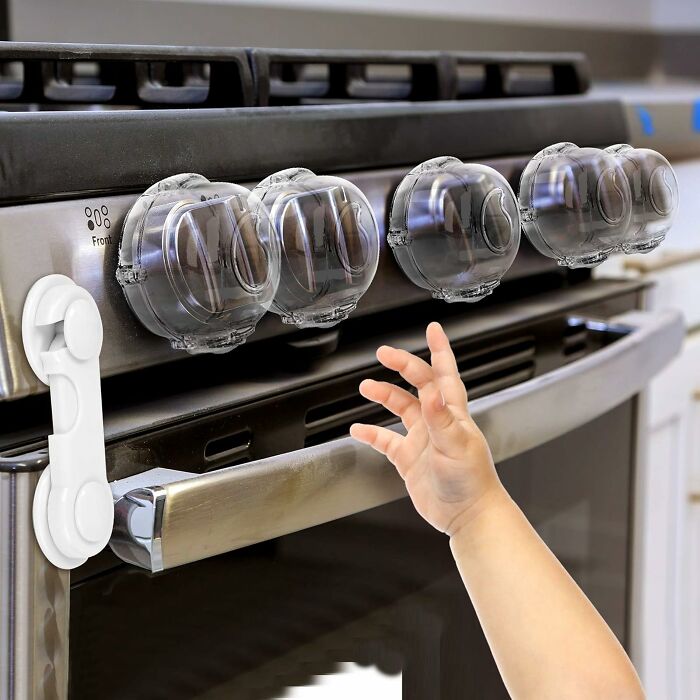 Child reaching for stove knobs protected by clear safety covers and a latch lock to prevent safety nightmares in homes.
