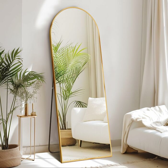 Tall gold-framed mirror with green plants and white sofa reflecting in a bright room, 5-star Prime Day finds featured.