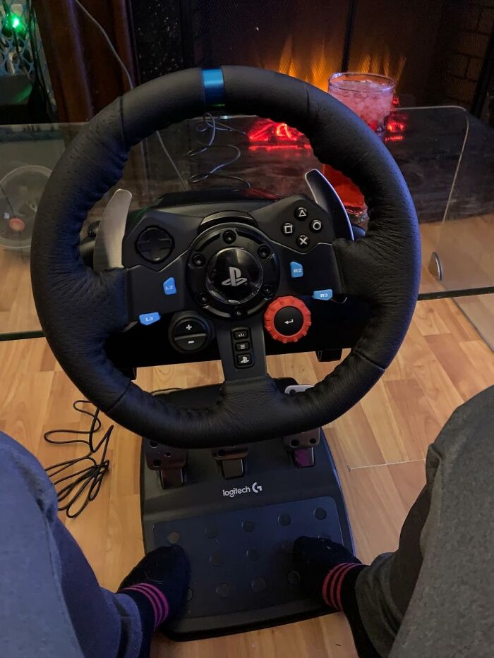 Gaming steering wheel and pedals setup on wooden floor, a perfect Prime Day treasure for immersive racing experiences.