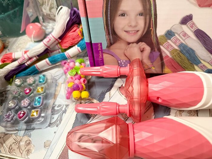 Infomercial finds crafting kit with beads, colorful threads, and styling tools on a table for creative DIY projects.