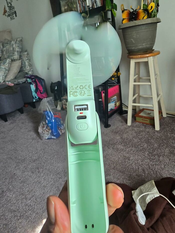 Portable handheld fan in use, showcasing a travel essential for your hot girl summer itinerary.