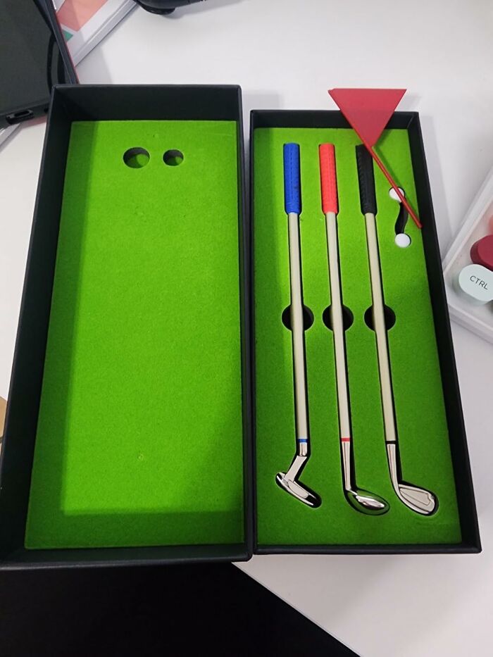 Miniature golf set with putters and flag in a box, perfect items to turn your workspace into a low-key holiday destination