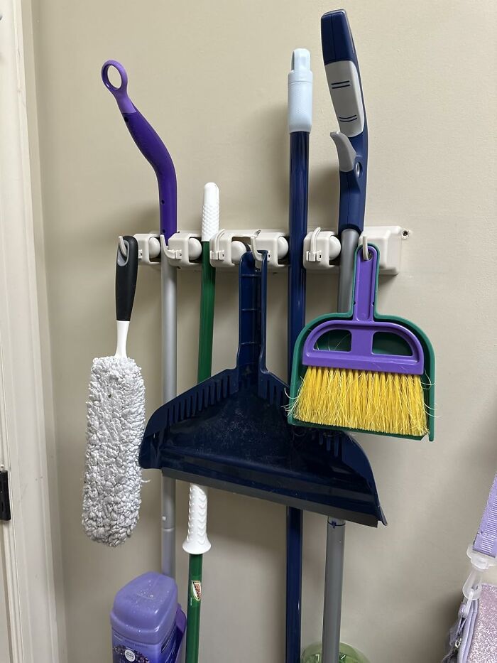Cleaning tools including dustpan, broom, mop, and duster organized on a wall rack, popular Amazon items selling fast.