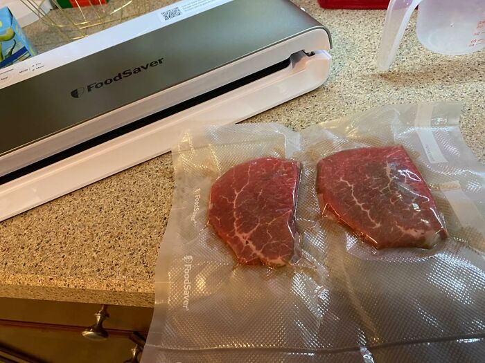 FoodSaver vacuum sealer packaging raw steaks as a popular infomercial find for food preservation and storage.