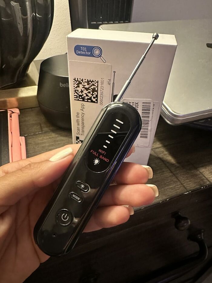 Hand holding a WiFi full band detector device, highlighting tools for safety fixes and night safety solutions.