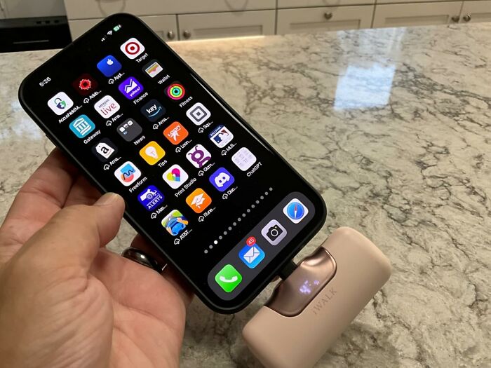 Smartphone connected to a portable charger on a marble countertop showing Prime Day treasures tech gadget.