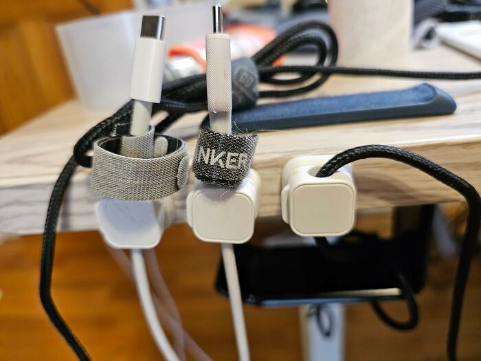 Organized charging station with multiple cables and plugs, one labeled with Anker, in a home or office setting.