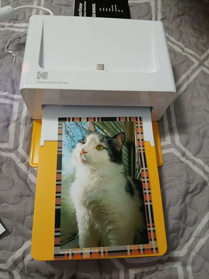 Portable photo printer printing a cat photo, ideal for getting your syllabuses ready with back-to-school deals on Prime Day.