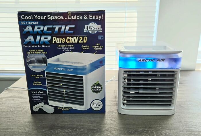 Arctic Air evaporative air cooler on table next to its box showing features for heatwave hacks and summer survival.