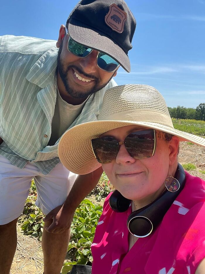 Two people wearing hats and sunglasses outdoors in a sunny field, enjoying heatwave hacks for summer survival.