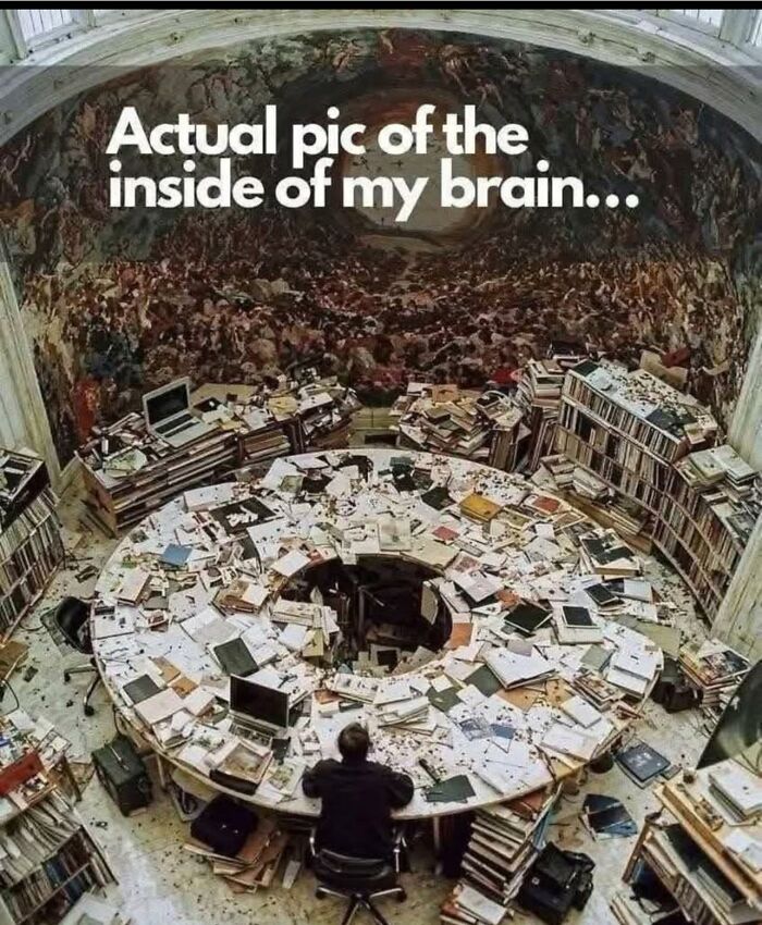 Cluttered circular workspace filled with papers and books depicting a neurodivergent's busy and chaotic mind.