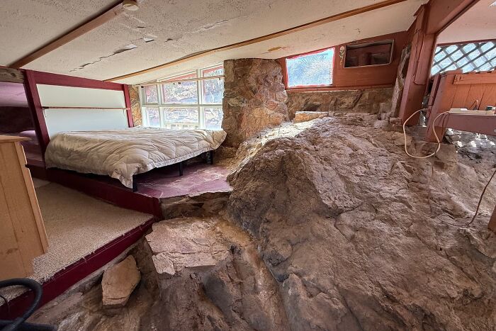 Unusual home interior with exposed rock formations creating a unique but impractical living space design.