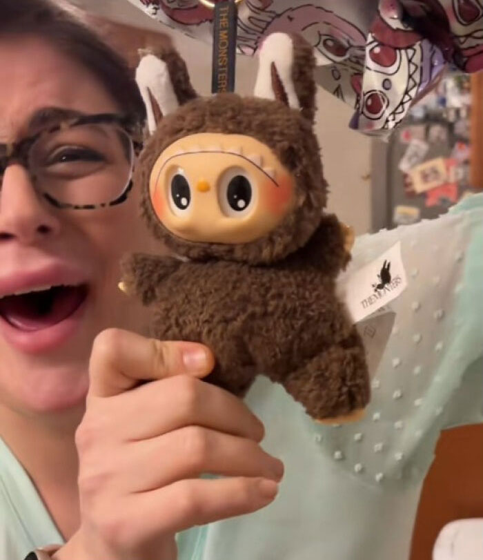 Person holding a creepy Labubus plush toy with big eyes and bunny ears, showcasing fake nightmare collectibles.