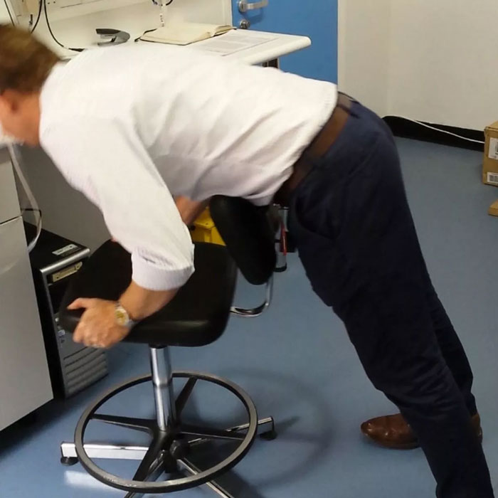 Person performing a safety exercise using an office chair, demonstrating tested tips to stay safe and alive.