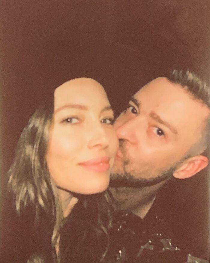 Close-up of a man kissing a woman on the cheek with warm lighting, related to Justin Timberlake Romania show viral reaction.
