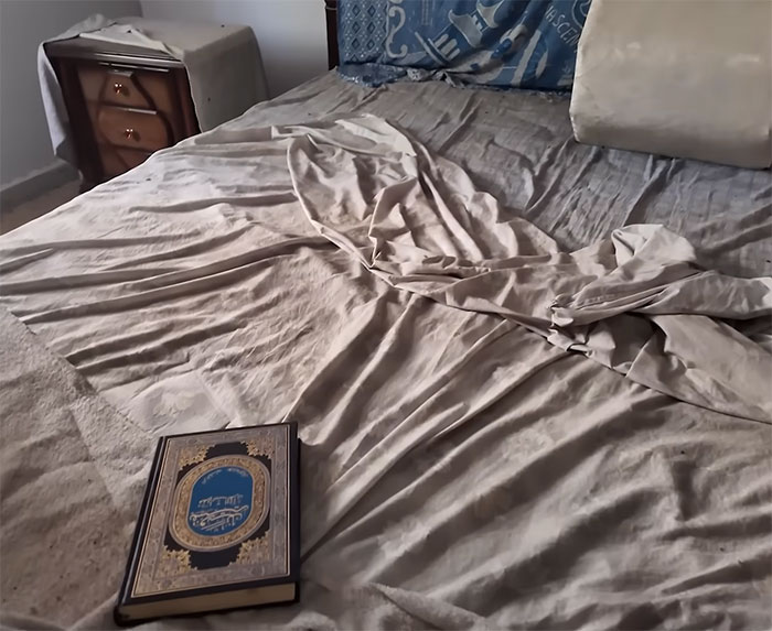 Old family bedroom with unmade bed and a book on the floor, tied to woman visits family home after 46 years. - 6