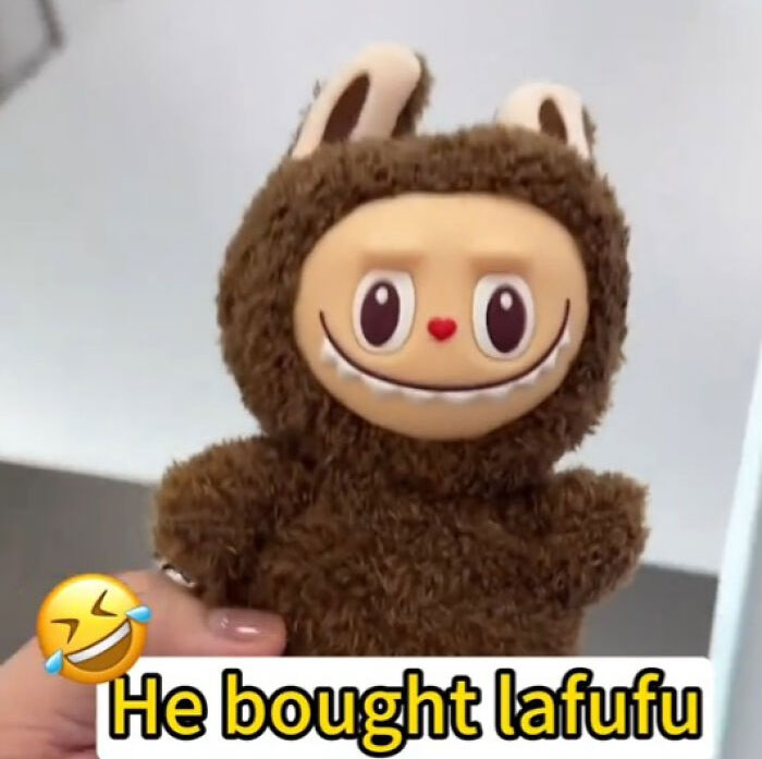 Hand holding creepy Labubus fake toy with a smiling face indoors, showcasing one of the 88 fakes that might give nightmares.