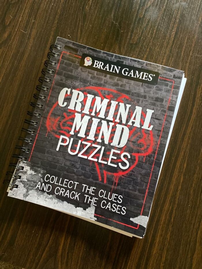 Brain games criminal mind puzzles book on wooden table, promoting skill time with fun hobbies.