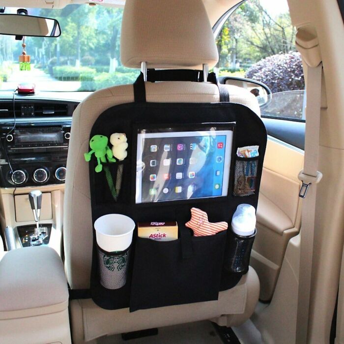 Car accessories organizer attached to passenger seat, offering storage for tablets, toys, drinks, and snacks.