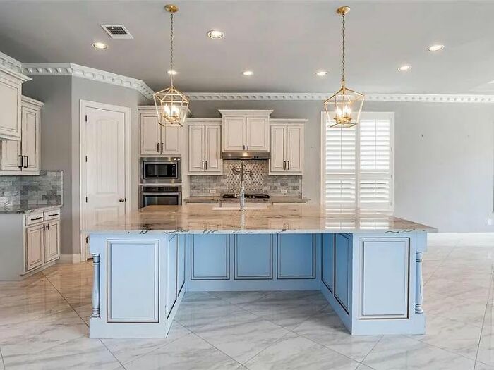 Modern kitchen design with marble floors, blue island, and classic cabinetry showing a home creative fail example.