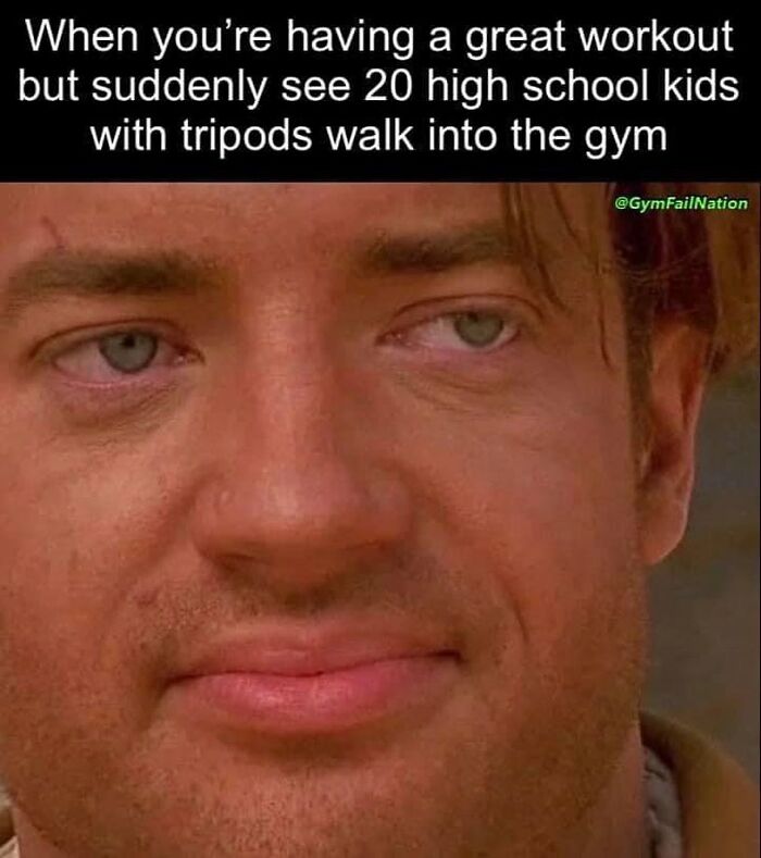 Close-up of a man's face showing mixed emotions, capturing a moment of gym humor with high school kids filming.