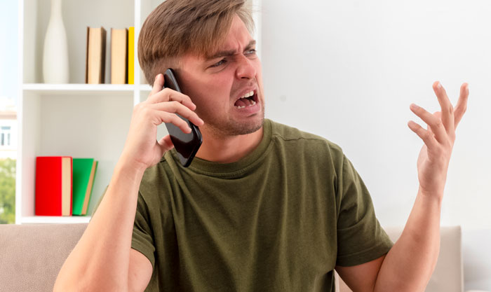Angry man talking on phone, frustrated about a resort room cancellation, relating to bride and guest conflict. - 5