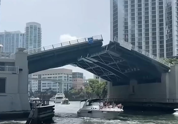 Boat passing under a rising drawbridge in an urban waterway where a woman survived after holding on for dear life. Boat passing under a rising drawbridge in an urban waterway where a woman survived after holding on for dear life.