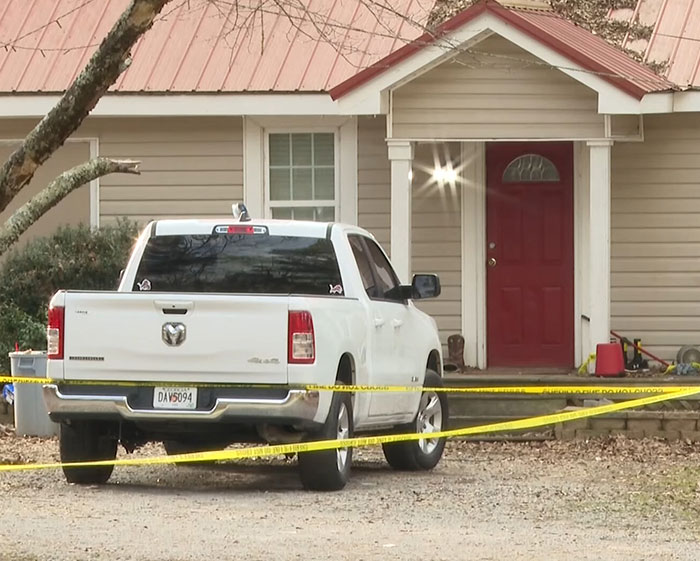 White pickup truck parked outside a house with police tape around, related to a girl finding parents' bodies incident.
