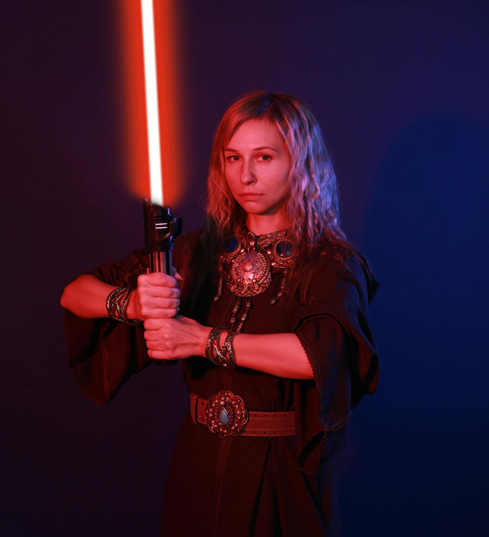 Woman holding a red glowing sword, dressed in medieval attire with intricate jewelry and a serious expression. - 8