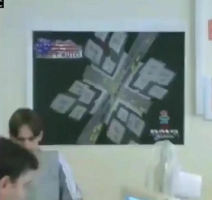 Two people working at computers with a blurred map on the wall, capturing nostalgic posts about growing up in the ’90s.