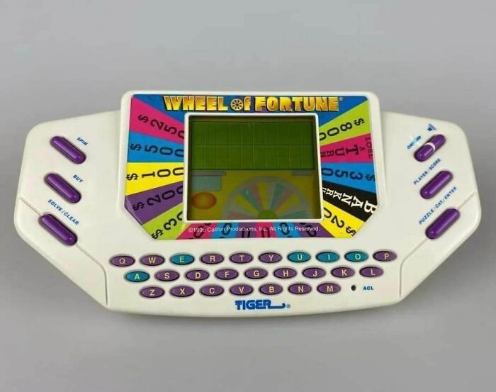 Tiger Electronics Wheel of Fortune handheld game with colorful buttons, capturing nostalgic posts about growing up in the ’90s.