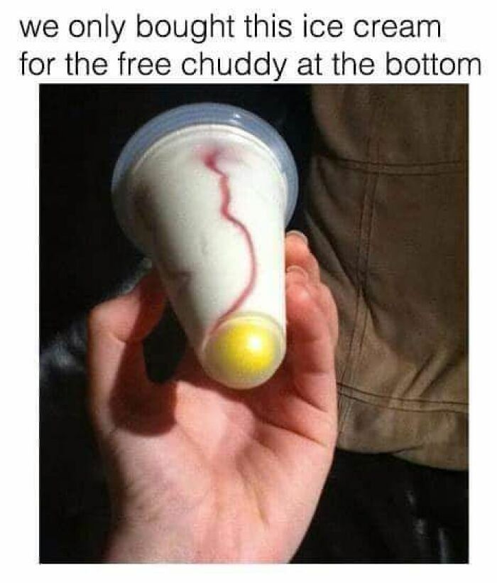 Hand holding nostalgic 90s ice cream with a yellow candy at the bottom, capturing the magic of growing up in the ’90s.