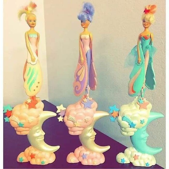 Three vintage 90s toys featuring fairies standing on crescent moons with stars, capturing nostalgic growing up moments.