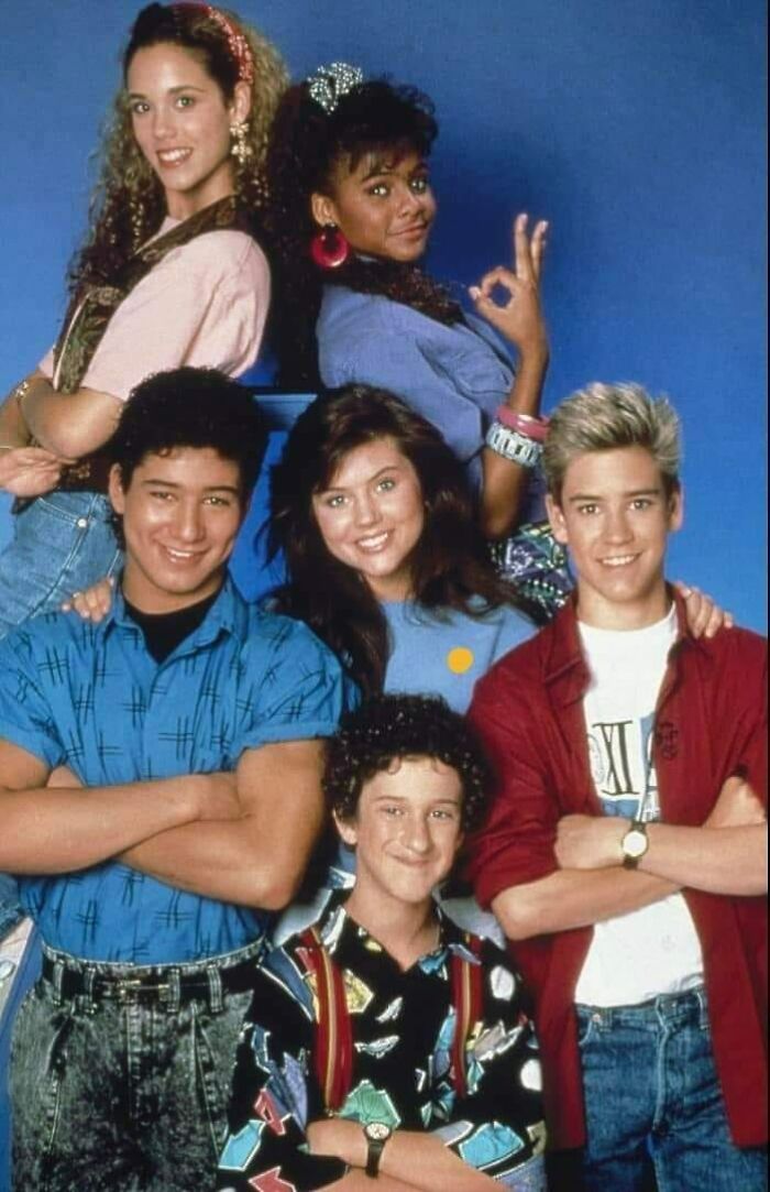 Cast of a popular 90s TV show posing together, showcasing nostalgic fashion and style from growing up in the 90s.