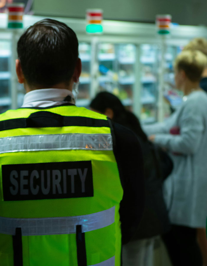 Security personnel in a high-visibility vest monitoring passengers after flight scare causes emergency landing.