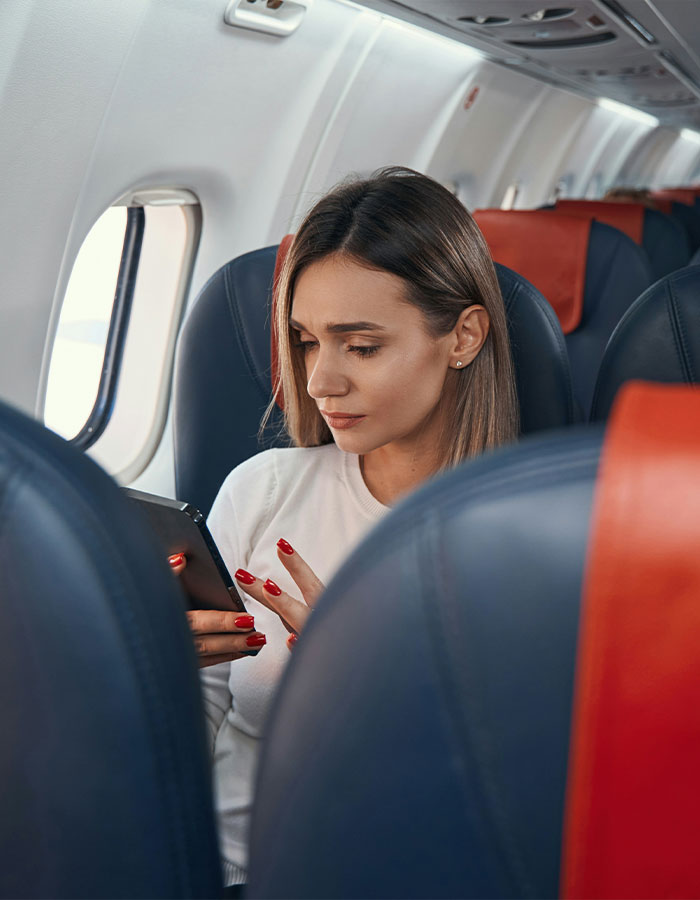 Passenger sitting on flight looking at phone, sparking scare and causing emergency landing after reading seat neighbor's text.