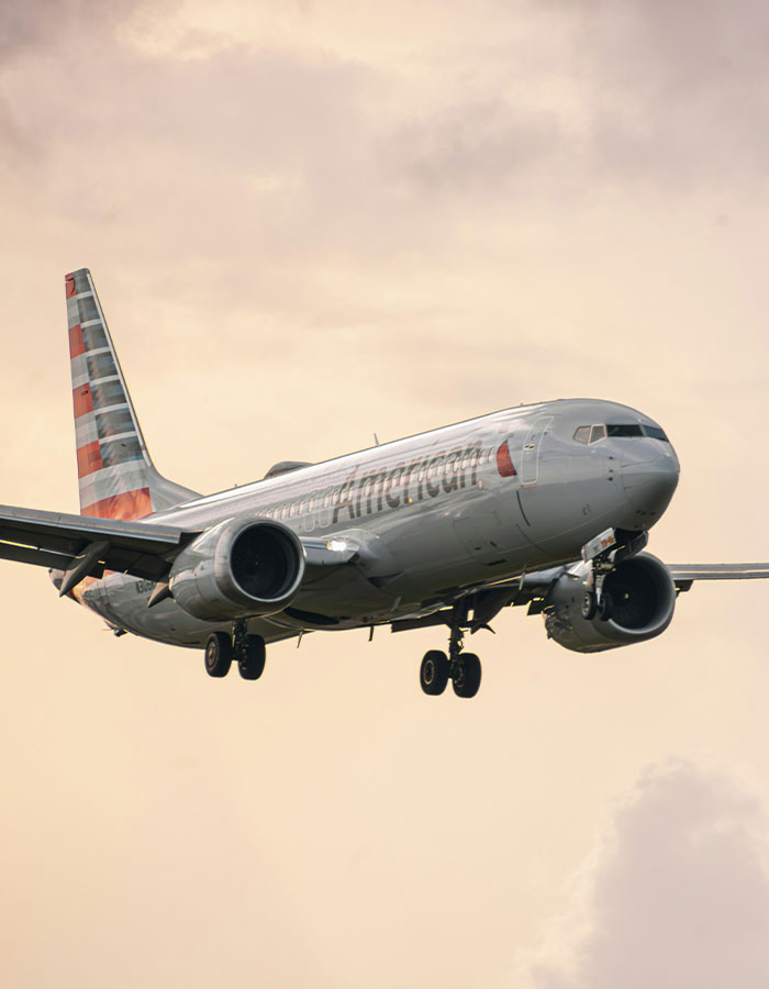 Passenger sparks scare on flight causing emergency landing, with airplane descending against cloudy sky background.