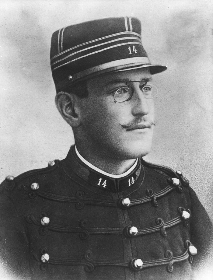 Black and white portrait of a vintage military officer wearing glasses and a numbered uniform, illustrating interesting rumors.