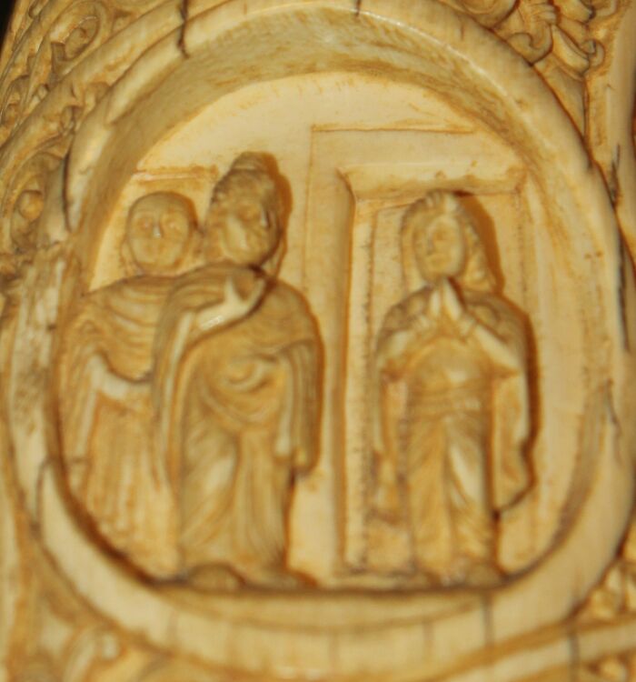 Carved ivory artwork depicting historical courtesans as power players in a detailed ancient scene.