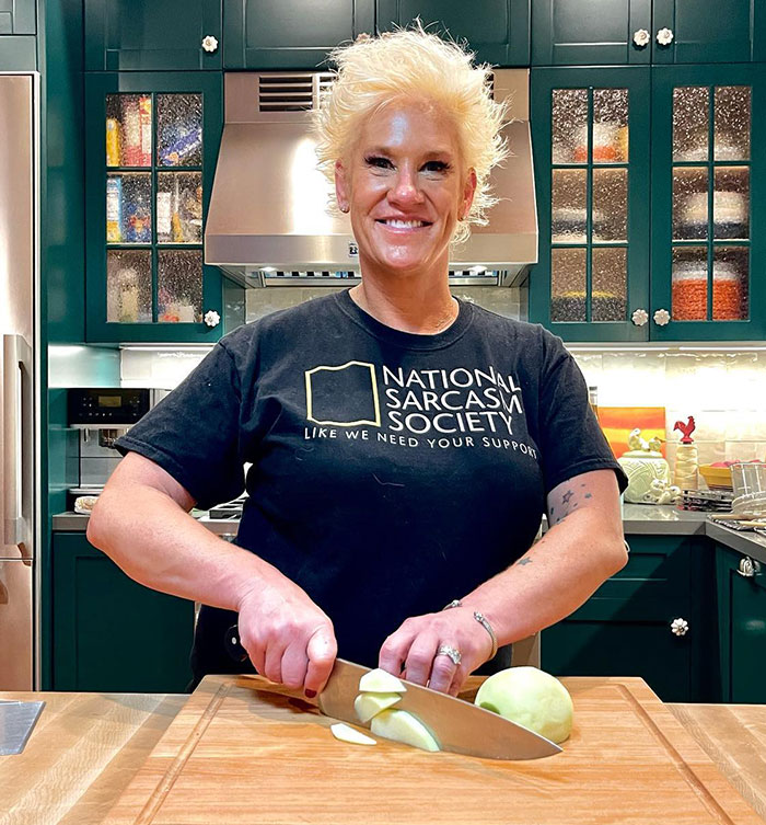 Master Chef Anne Burrell smiling in kitchen while slicing an onion, related to medical examiner's report findings. - 4