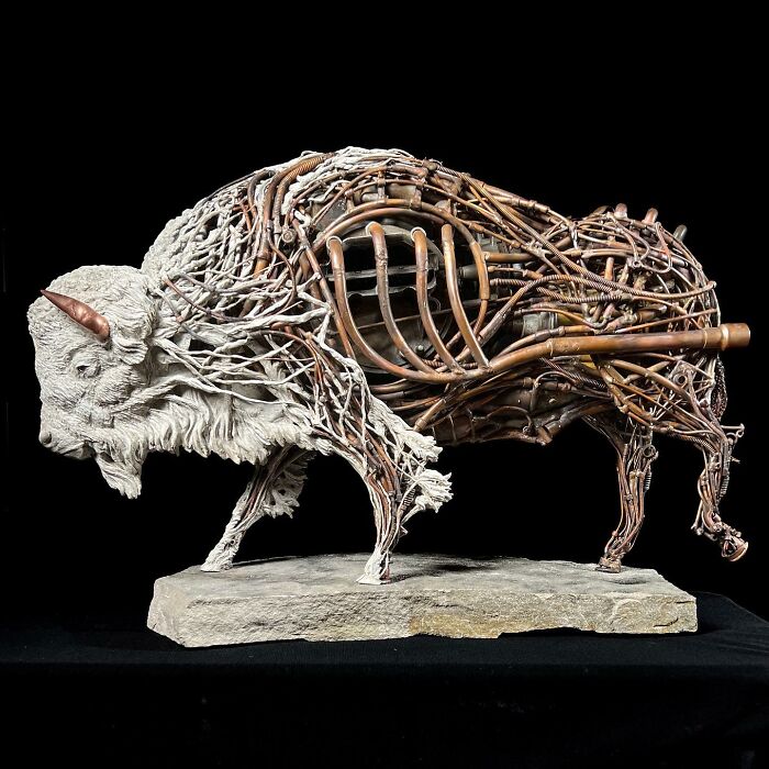 Buffalo sculpture crafted from scrap metal and wire showcasing intricate animal sculpture artistry on a stone base.