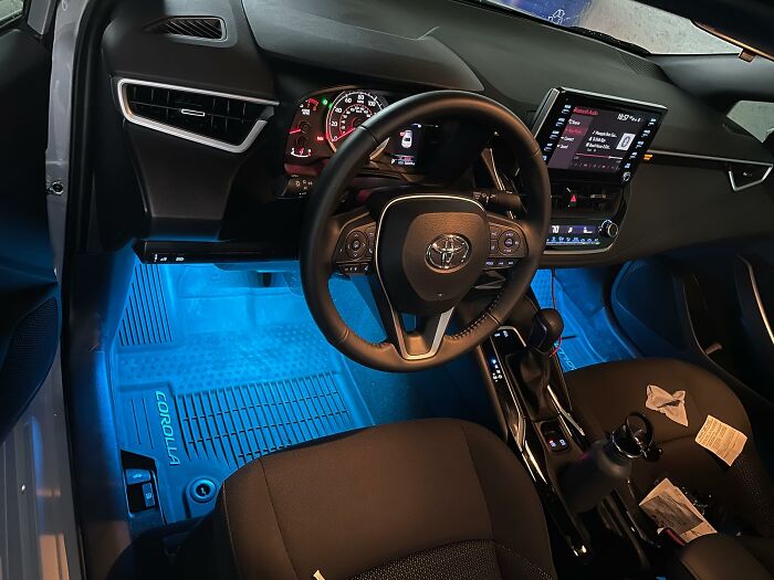 Interior view of a car showcasing organized storage and illuminated floor mats, highlighting practical car accessories.